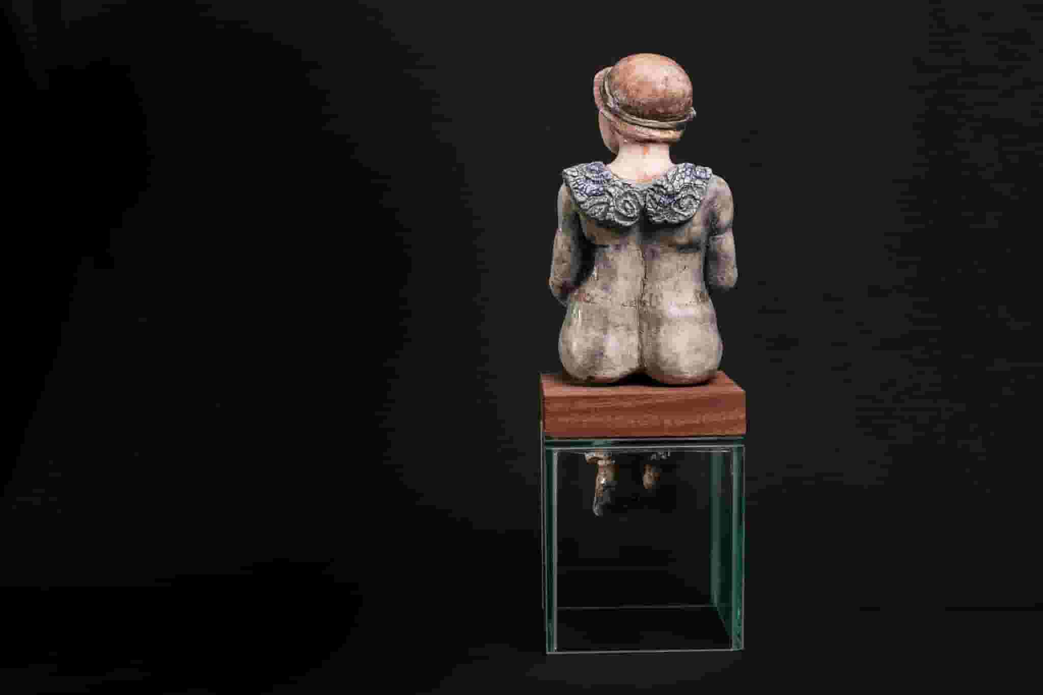 Vista posterior de figura sentada